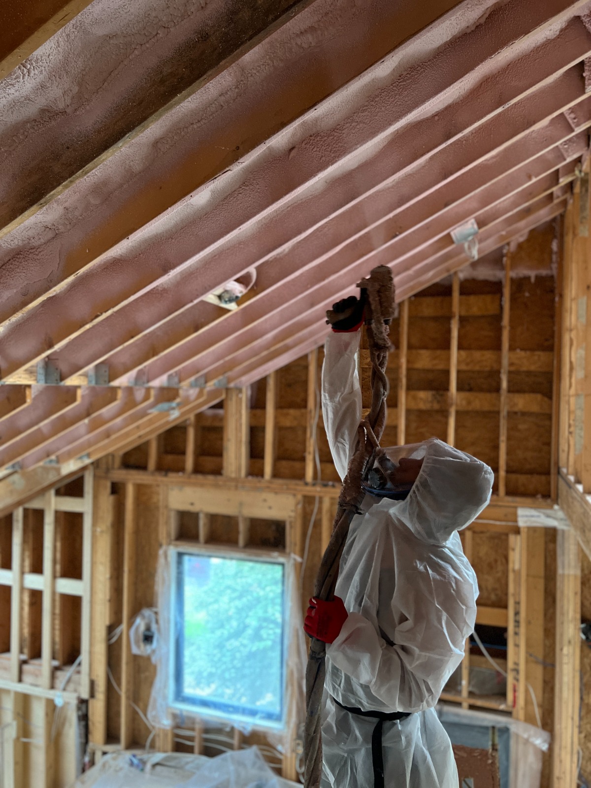 Spray foam insulation being applied to wall cavities